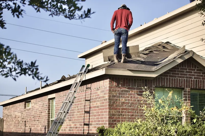 Professional roofer working on a residential roof in Heritage Dells